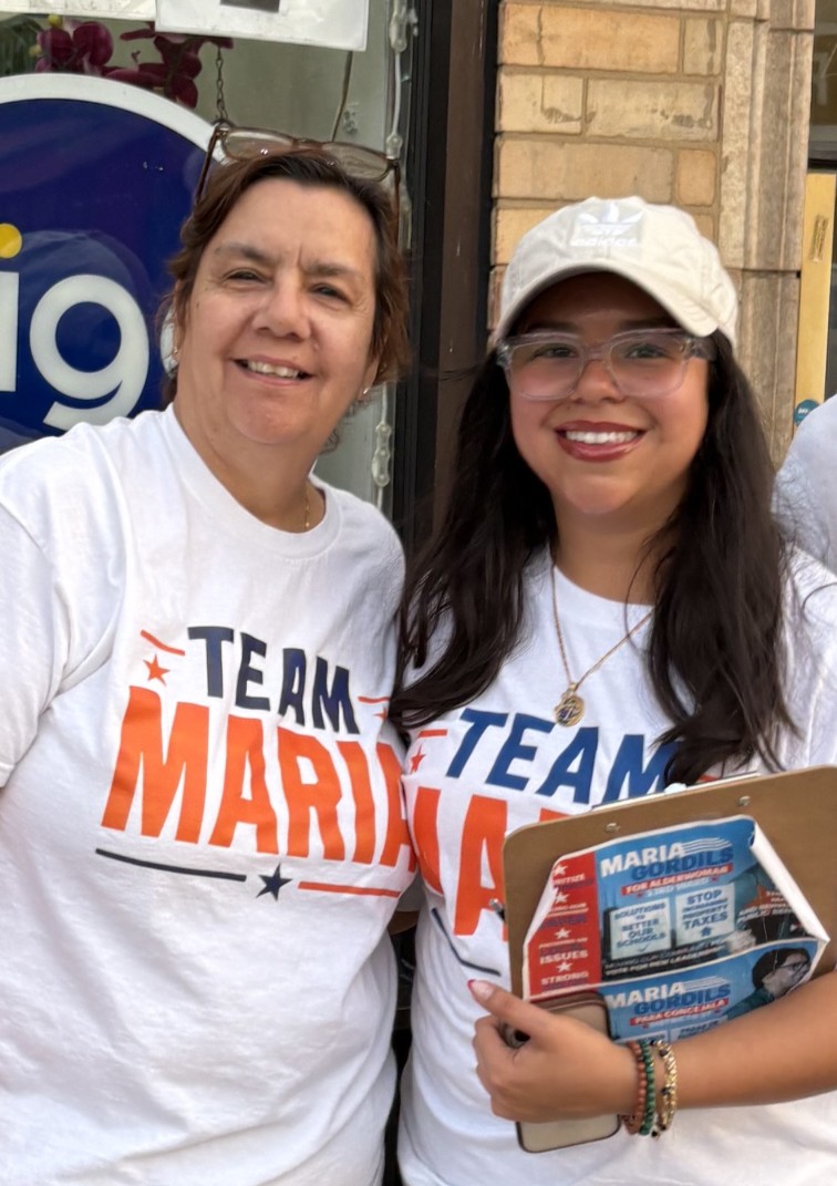 Two women standing on sidewalk in front of store.